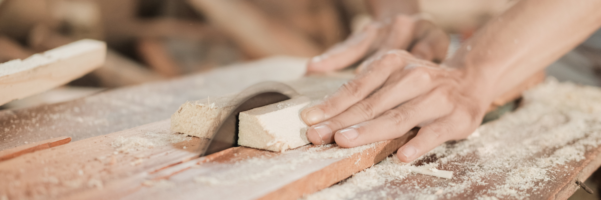 Eine Person schneidet mit einer Kreissäge ein Holzstück durch